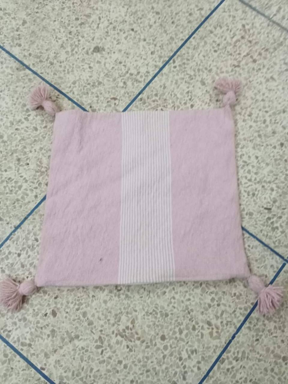 Coussin artisanal tissé à pompons rose