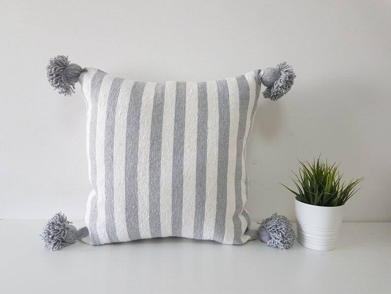 Coussin marocain à pompons rayé gris et blanc