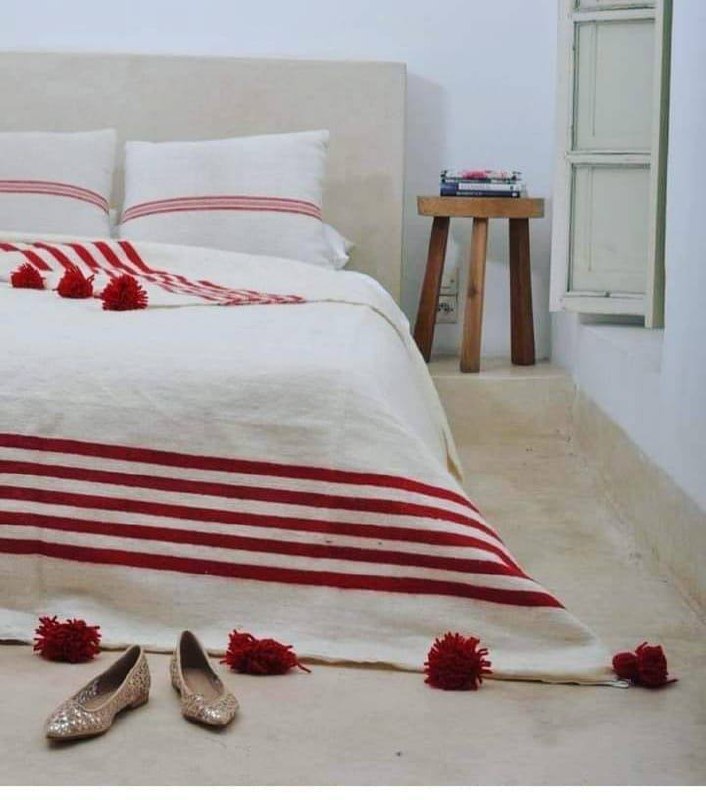 Couverture berbère à rayures et pompons rouges