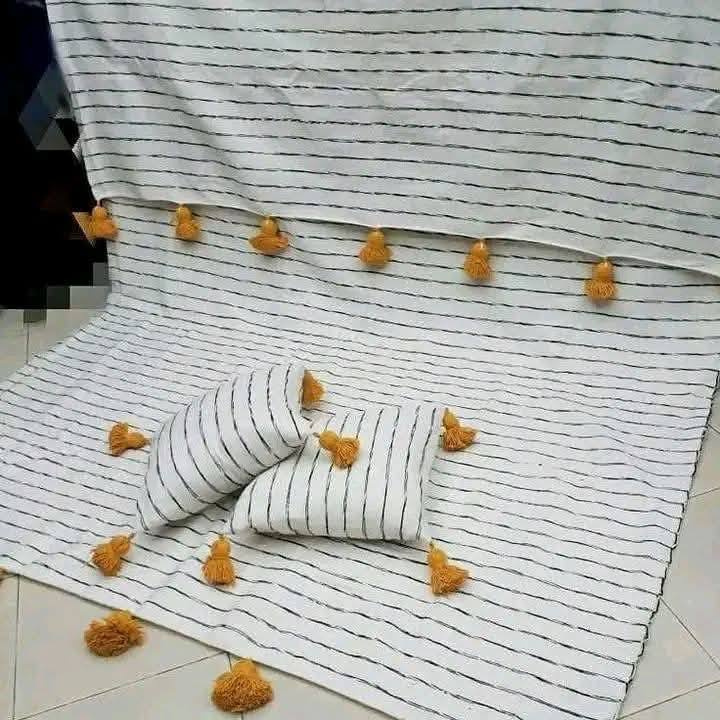 Couverture et coussin tissés à pompons dorés
