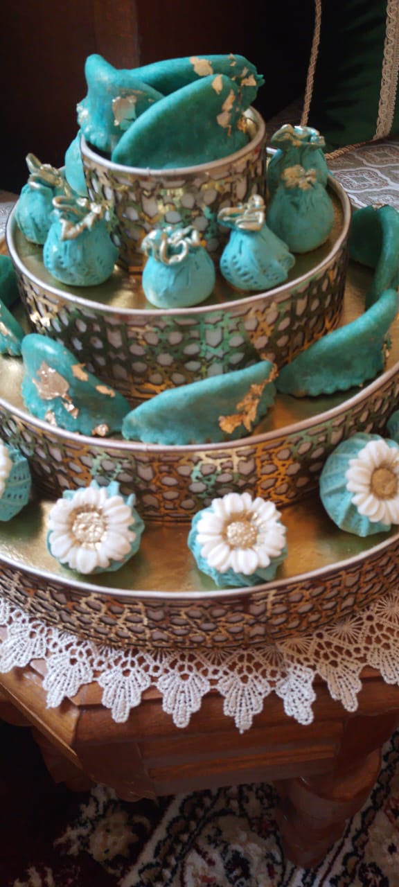Assortiment pâtisseries orientales turquoise et blanches sur présentoir doré